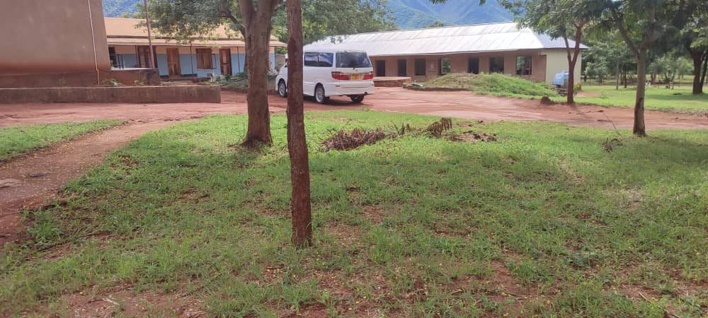 The school grounds, with classroom blocks on both sides and the mountains behind